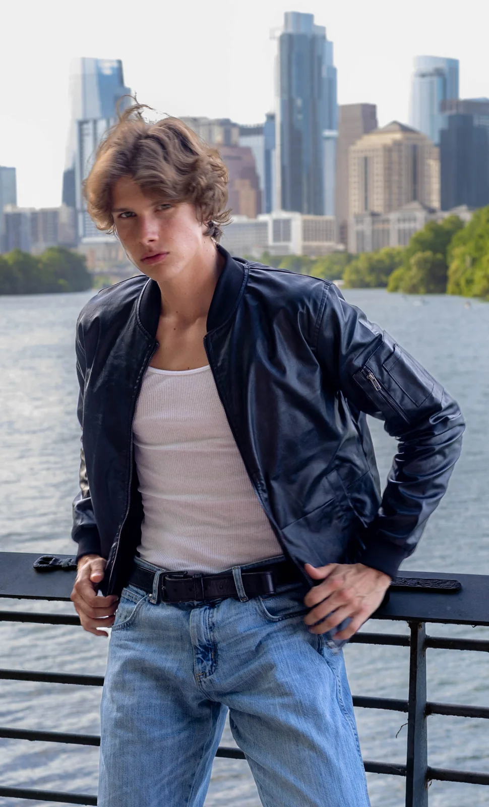 Man in the black Summit Classic Bomber with the Austin skyline behind him