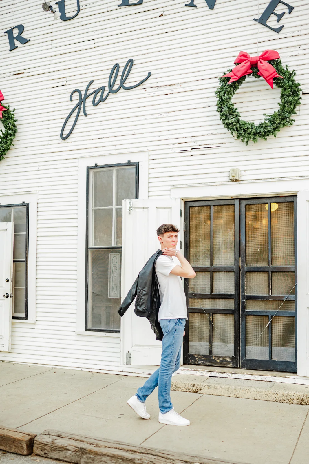 Man in the black Summit Classic Bomber walking past Gruene Hall, Texas